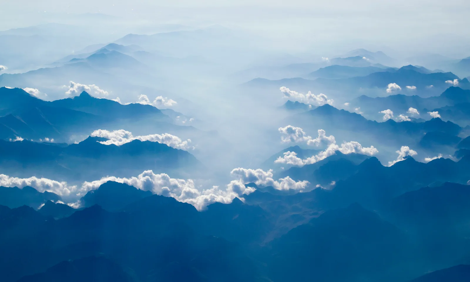 上空から見た、青い霞の中の山並みと雲